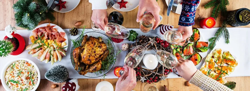 mesa en la cena de navidad y personas brindando con sus copas